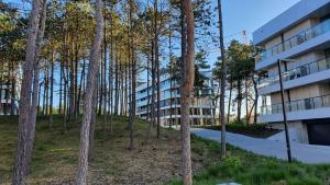 an apartment building next to a forest of trees at Apartamenty przy plaży Shellter in Rogowo
