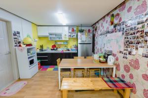 a kitchen with a table and a kitchen with a refrigerator at Panda Guesthouse in Gwangju