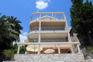 a building with two umbrellas in front of it at Swiss Residence Montenegro in Herceg-Novi