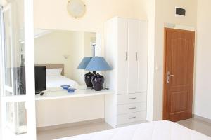 a bedroom with a bed and a desk with a television at Swiss Residence Montenegro in Herceg-Novi