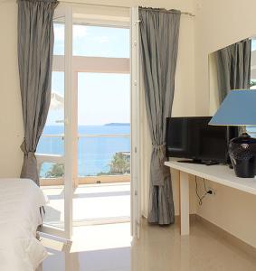 a bedroom with a window with a view of the ocean at Swiss Residence Montenegro in Herceg-Novi
