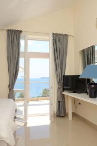 a bedroom with a window with a view of the ocean at Swiss Residence Montenegro in Herceg-Novi
