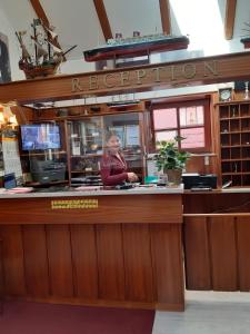 Eine Frau, die hinter einer Bar in einem Restaurant steht. in der Unterkunft Hotel Columbus und Glamping in Bremerhaven