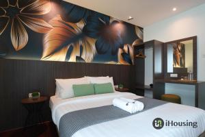 a bedroom with a large bed with a painting on the wall at Trevor Hotel Malacca Town By I Housing in Malacca