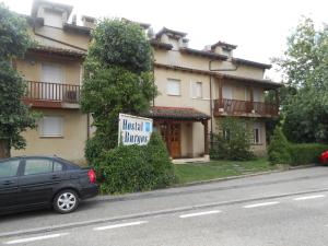 托雷卡瓦列罗斯Hostal Burgos的停在大楼前的带有标志的汽车