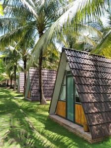szereg domków pod palmami w obiekcie Phu Nam House - Resort w Duong Dong