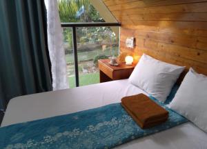 a bedroom with a bed with a large window at Phu Nam House - Resort in Phú Quốc