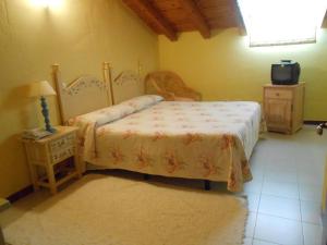 een slaapkamer met een bed en een tafel met een lamp bij Hostal Burgos in Torrecaballeros