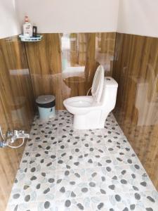 a bathroom with a white toilet and a shower at Phu Nam House - Resort in Phú Quốc