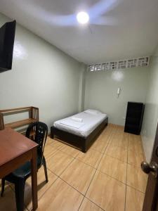 a small room with a bed and a table at Alojamiento Tahuari - Iquitos- Perú in Iquitos