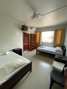 a hotel room with two beds and a window at Alojamiento Tahuari - Iquitos- Perú in Iquitos