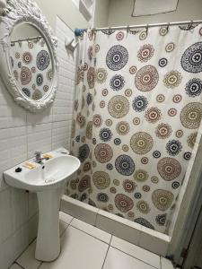 a bathroom with a sink and a shower curtain at Alojamiento Tahuari - Iquitos- Perú in Iquitos +150 photos