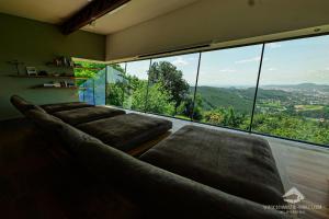 ein Wohnzimmer mit einem großen Fenster und einem Sofa in der Unterkunft Schmolti's Chalet in Graz