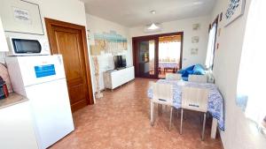 Sardegna - Villa Mirto & Flowers في أولبيا: مطبخ وغرفة طعام مع طاولة وثلاجة