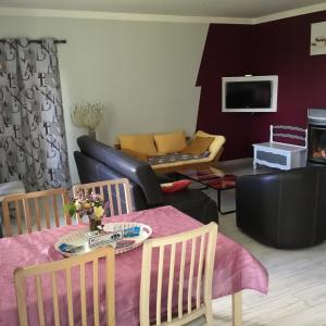 ein Wohnzimmer mit einem Tisch und einem Sofa in der Unterkunft Au bord de l'eau in Charentenay