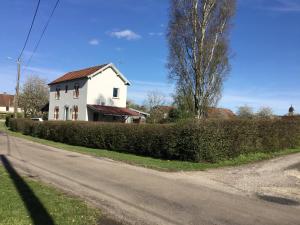 una casa blanca al lado de una carretera en Au bord de l'eau, en Charentenay