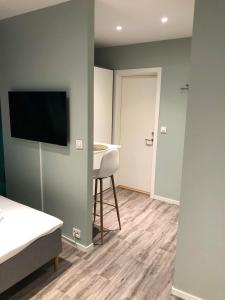 a room with a bed and a television on a wall at Central studio apartment Apt 104 in Stavanger