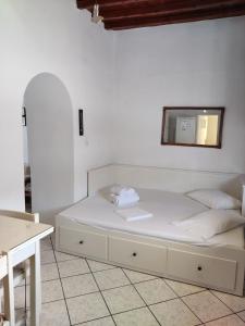 a bed in a room with a mirror on the wall at Family house by the seaside of Karavostasis in Karavostasi