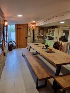Kuća za odmor Apathy في Opatovac: طاولة خشبية كبيرة في مطبخ مع مقاعد