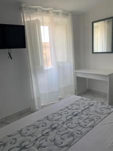 a white bedroom with a bed and a desk at Le Case di Don Andrea in Minori