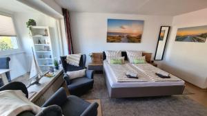 sala de estar con 1 cama y 2 sillas en Fewo-Elbsicht-405 en Cuxhaven