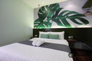 a bedroom with a large white bed with towels on it at Trevor Hotel Malacca Town By I Housing in Malacca