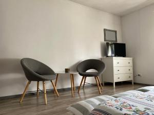 two chairs and a table in a bedroom at Casa de Vacanta Potoc in Potoc