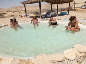 a group of women sitting in a swimming pool at צימראוון בחוות זית המדבר in Sde Boker