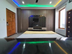 Bāra BankiにあるSurja Resortのベッドと壁掛けテレビのある寝室