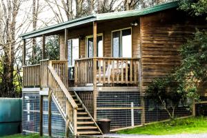 a wooden cabin with stairs and a porch at Drumreagh Cabins in Deloraine
