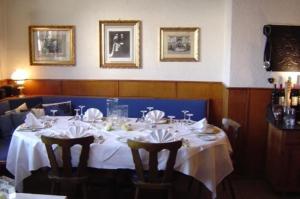 Hotel & Restaurant Raisch في Steinwenden: غرفة طعام مع طاولة مع قماش الطاولة البيضاء