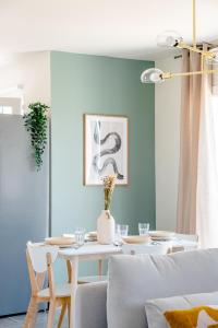 een eetkamer met een witte tafel en een blauwe muur bij Havre de nature Provence in Morières-lès-Avignon
