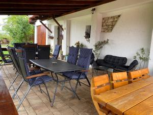 a patio with a table and chairs and a couch at Casa de Vacanta Potoc in Potoc