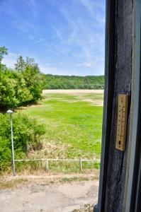 una ventana de tren con vistas a un campo de césped en confortable maison familiale à l'entrée du village médiéval, en Noyers-sur-Serein