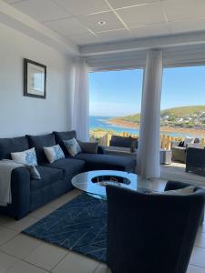 a living room with a blue couch and a table at Au Petit Brick - Cosy beachfront house in Maupertus-sur-Mer