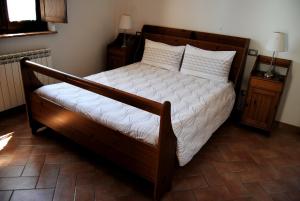 モンテプルチャーノにあるAgriturismo La Fornace di Poggianoのベッドルーム1室(白いシーツが備わる木製ベッド1台付)
