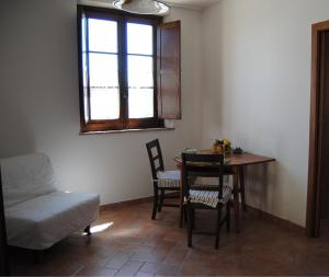 a living room with a table and chairs and a window at Agriturismo La Fornace di Poggiano in Montepulciano