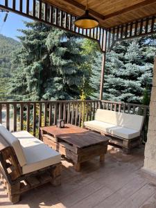 - un kiosque en bois avec une table et des chaises sur une terrasse dans l'établissement Kirovi Tun, à Dilidjan