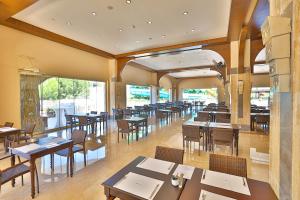 シダにあるCrystal Sunset Luxury Resort & Spa - Ultimate All Inclusiveの木製のテーブルと椅子、窓のあるレストラン