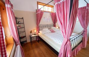 a bedroom with a bed with red and white curtains at Troadkasten - Ferienhaus am BIO-Bergbauernhof in Aflenz Kurort