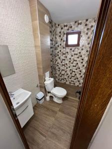 a bathroom with a toilet and a sink at Stamatovi Family Hotel in Pomorie