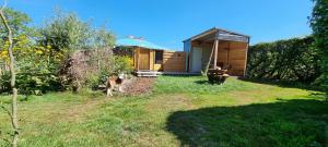 a dog standing in front of a small house at Yurt in Liempde