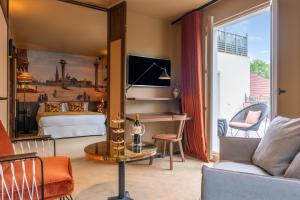 um quarto com uma cama e uma sala de estar em Les Etangs de Corot em Ville-dʼAvray
