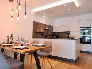 een keuken en eetkamer met een houten tafel en stoelen bij Apartment Auszeit in Gröbming