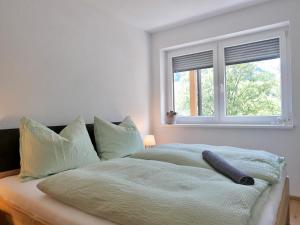 a white bedroom with a bed with a window at Apartment Auszeit in Gröbming