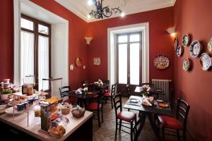a dining room with tables and chairs and red walls at Antiche Volte in Catania