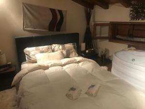 sypialnia z białym łóżkiem i 2 kapciami w obiekcie Σαλέ w mieście Akrata
