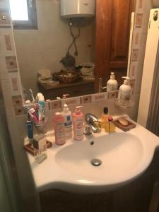 W łazience znajduje się umywalka z mydłem i zestaw kosmetyków. w obiekcie Σαλέ w mieście Akrata