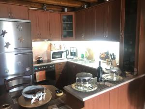 eine Küche mit einem Kühlschrank und einer Theke mit einem Tisch in der Unterkunft Σαλέ in Akráta