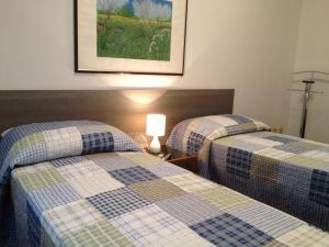 um quarto de hotel com duas camas com uma fotografia na parede em Appartamenti del Corso em Cuneo